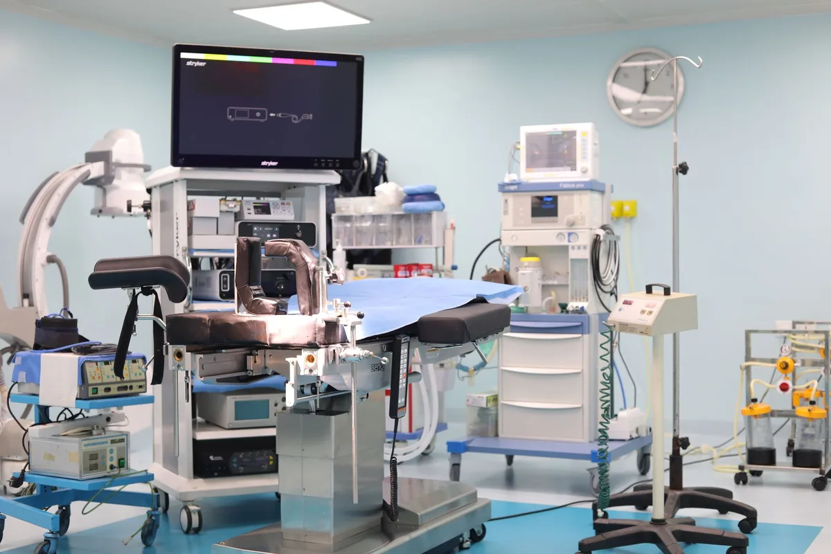 A fluoroscopic C-arm positioned over a procedure table in a darkened suite.