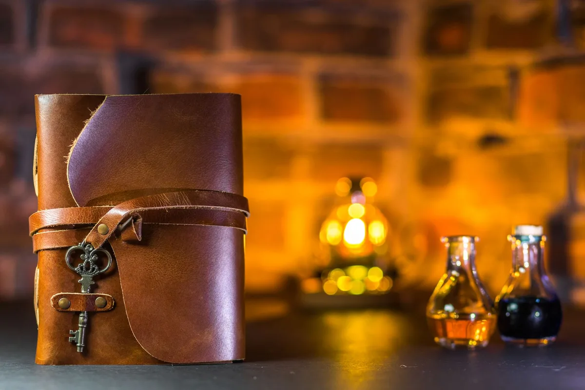 Antique books and a pocket watch on black, lit from one side.