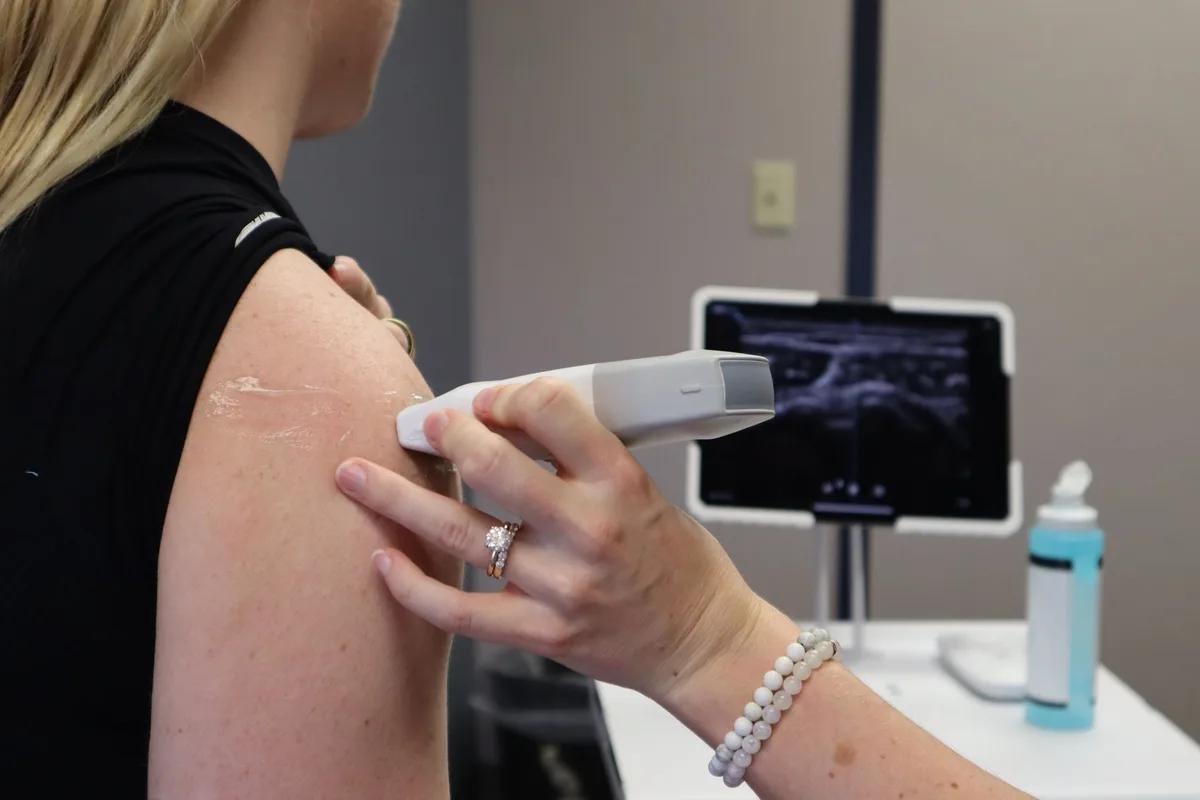 A calibrated sensory testing probe against skin in low light.